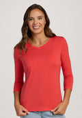 Smiling woman with long brown hair wears a Woolx Elena 3/4 Sleeve V Neck - Hibiscus and blue jeans, looking stylish. | Madeleine is 5’10”, wearing a size XS