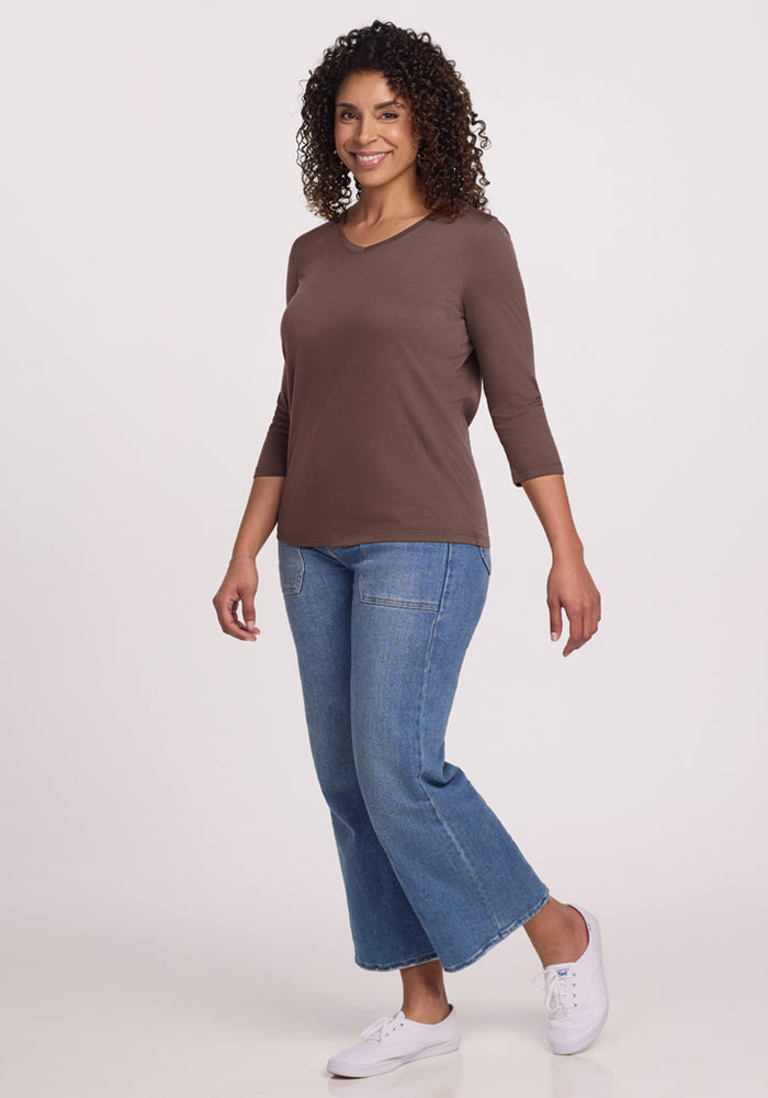 Woman wearing the Woolx Elena 3/4 Sleeve V Neck in Peppercorn, blue cropped jeans, and white sneakers, smiling.