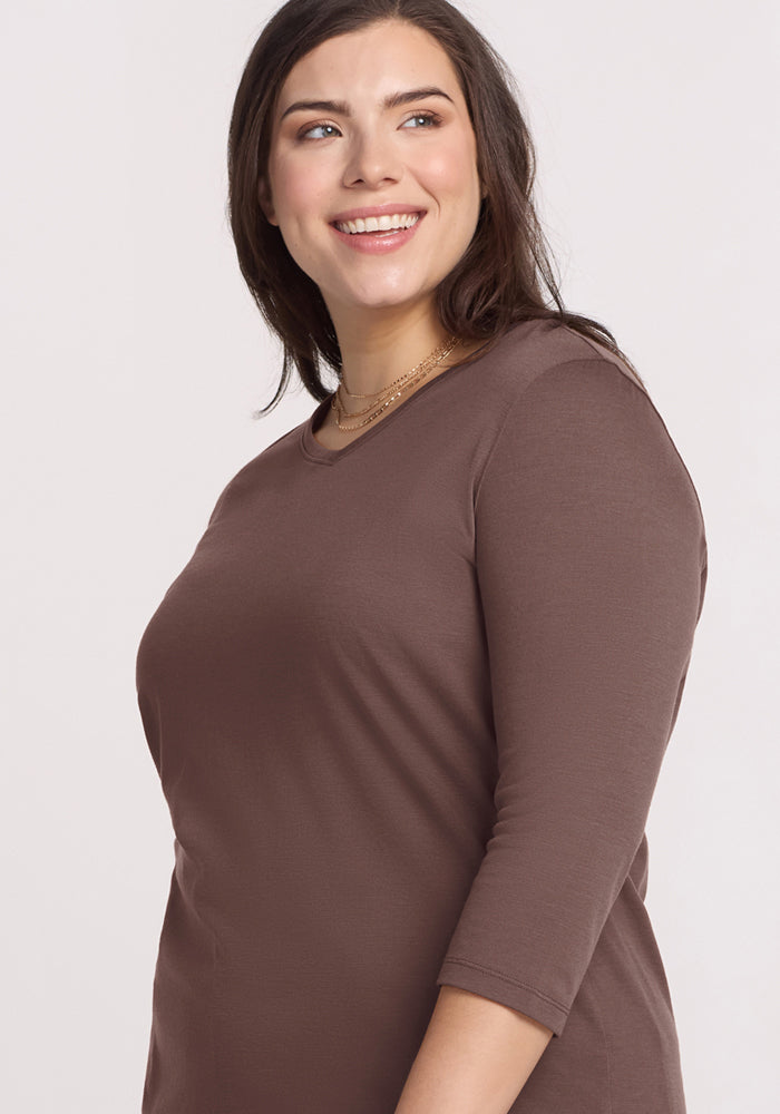 Woman with long brown hair wears the Woolx Elena 3/4 Sleeve V Neck in Peppercorn, smiling against a light background.