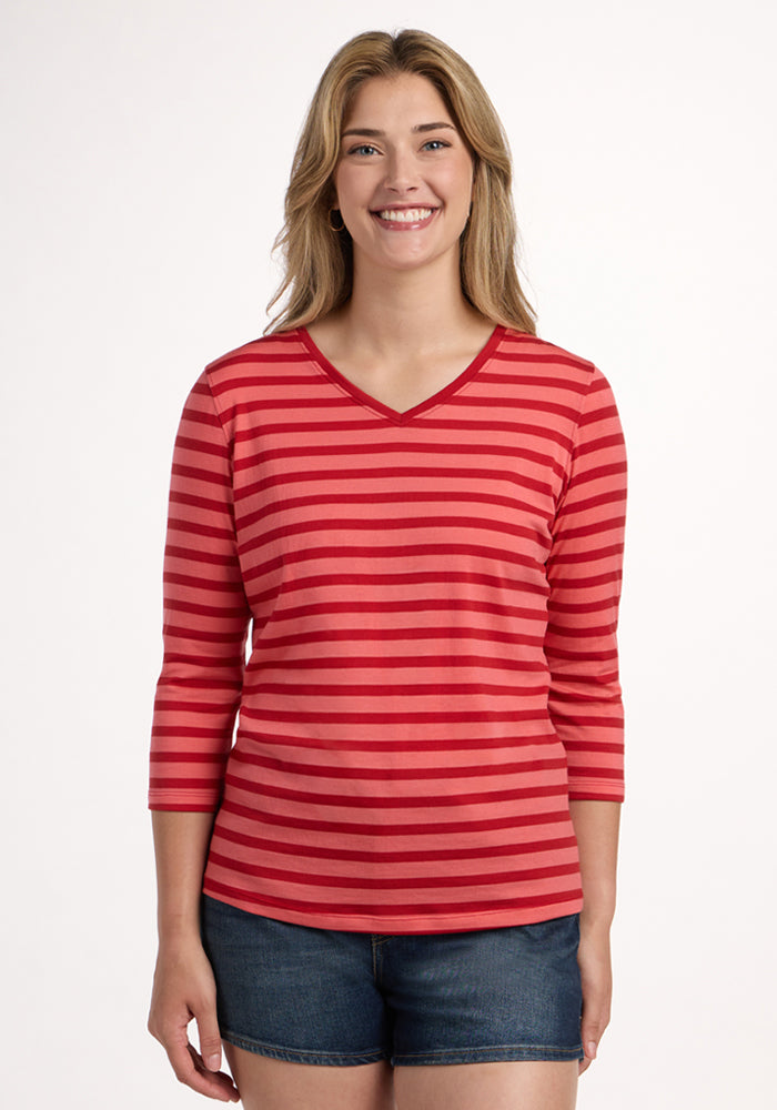 Woman smiling in the Woolx Elena 3/4 Sleeve V Neck - Wildberry Stripe, paired with denim shorts on a white background. | Ariana is 5'11", wearing a size S