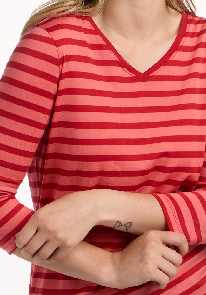 Woman in a Woolx Elena 3/4 Sleeve V Neck - Wildberry Stripe, butterfly tattoo on forearm, arms crossed.