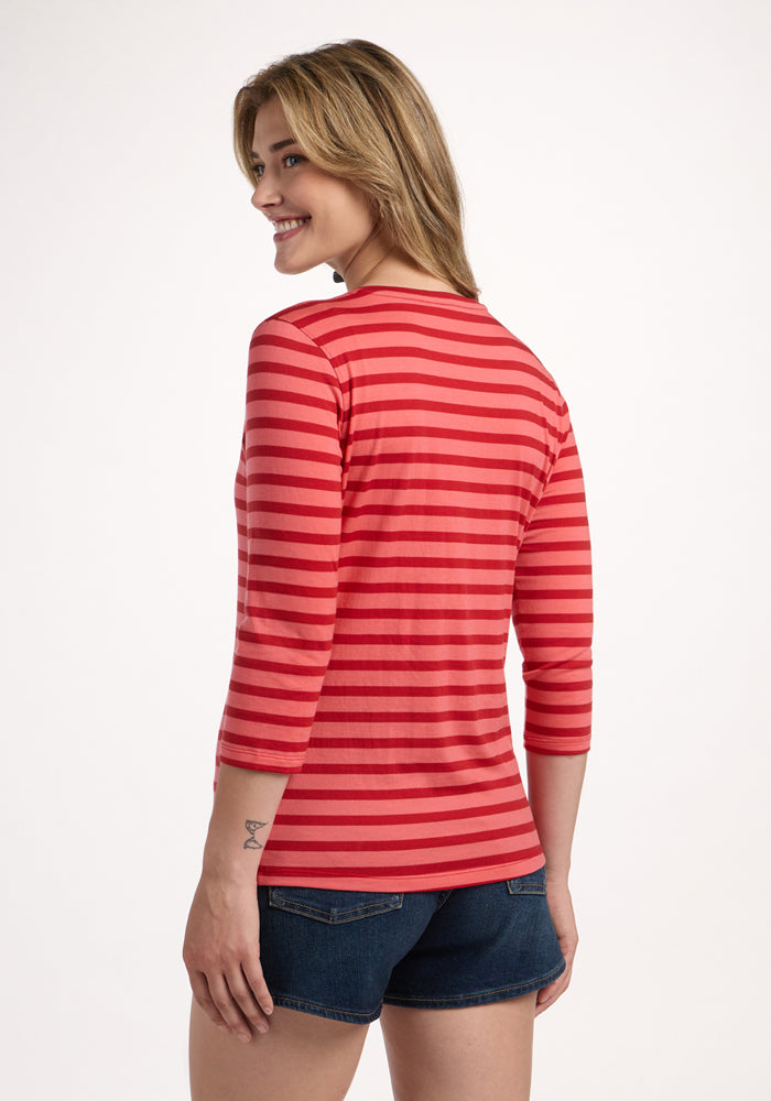 Woman in a Woolx Elena 3/4 Sleeve V Neck - Wildberry Stripe and denim shorts, smiling away from the camera.