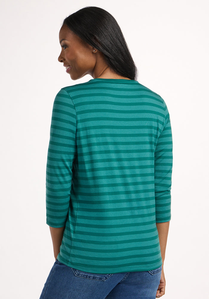 Smiling woman in the Woolx Elena 3/4 Sleeve V Neck - Woodland Stripe, green and teal stripes add charm.