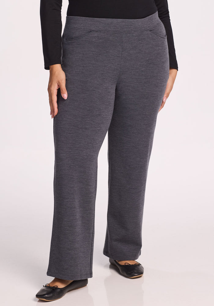A person wears Woolx Ellie Wide Leg Pants in Cinder Melange, styled with black flats, standing against a plain background. Their arms rest naturally by their sides, and only the lower body is visible. | Juliana is 5'10", wearing a size XL