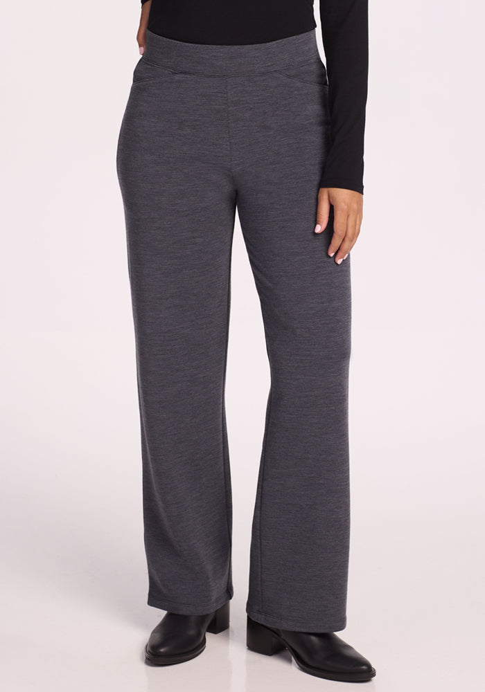 A person wears Woolx Ellie Wide Leg Pants in Cinder Melange, paired with a black long-sleeve top and black heeled ankle boots, standing against a plain light background. Only the lower half of the body is shown. | Tori is 5'7", wearing a size S