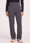 A person wears Woolx Emerson Straight Leg Pants in Cinder Melange, a long-sleeve black top, and white sneakers with black accents, standing against a plain light background. | Tori is 5'7", wearing a size S