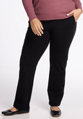 A person in a pink long-sleeve top and Woolx Emerson Straight Leg Pants stands with one hand in a pocket and the other resting at their side. They are wearing black flats. The focus is on the lower half of the body against a white background, highlighting the comfortable work pants crafted from Merino Wool in black. | Juliana is 5'10", wearing a size XL