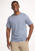 Smiling man in Woolx Endurance Tee - Blue Sand Mini Stripe and beige pants, standing against a white background. | Trell is 6’2”, wearing a size M