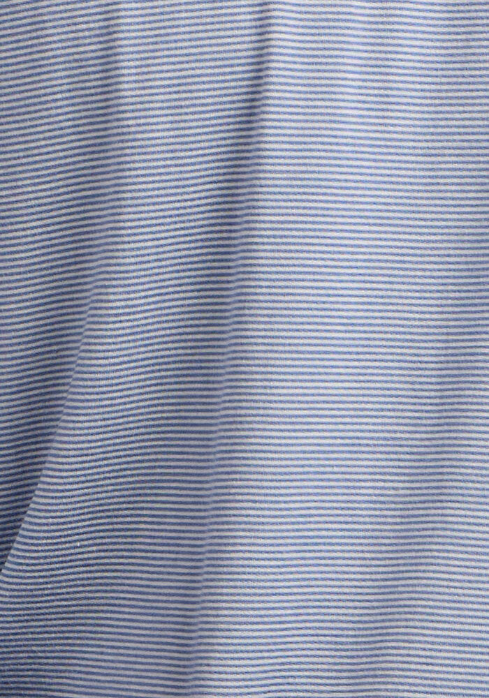 The Woolx Endurance Tee - Blue Sand Mini Stripe features soft Merino wool in light blue with fine, even white stripes. Its flexible texture and subtle sheen make it perfect for travel shirts or essential performance gear.