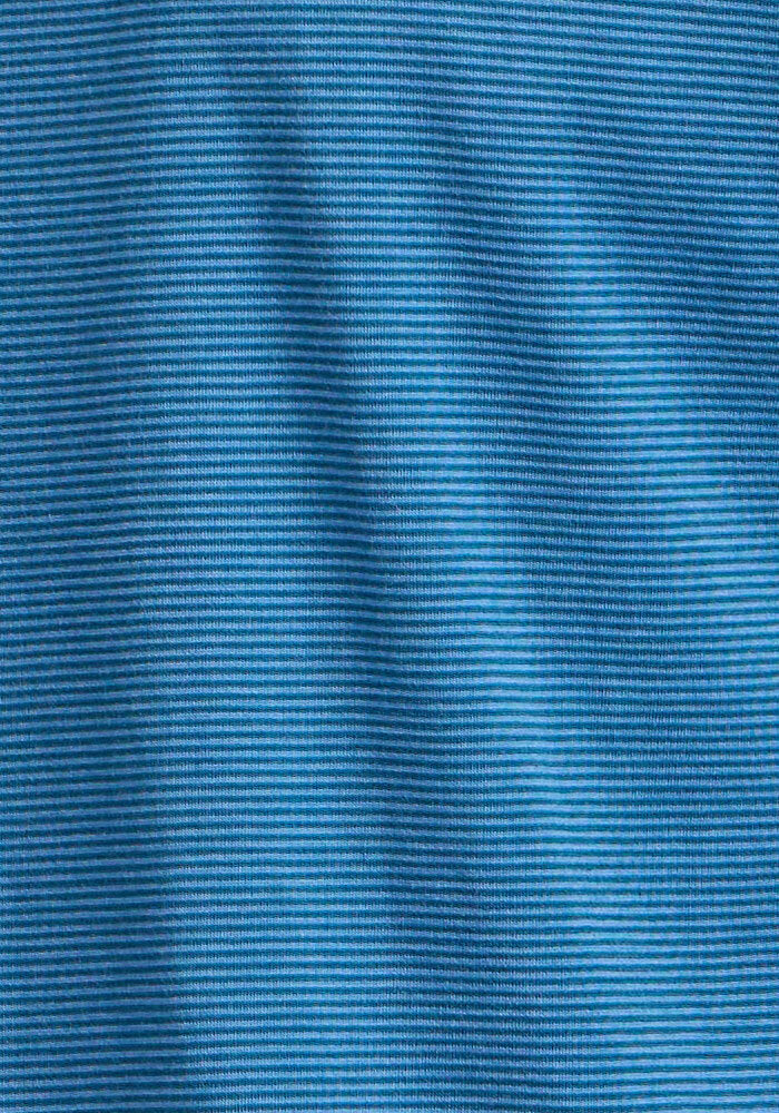 Close-up of blue fabric with fine horizontal ribbed texture shows subtle waves and shadows—ideal for the Woolx Endurance Tee - Coastal Mini Stripe, a Merino wool travel performance shirt.
