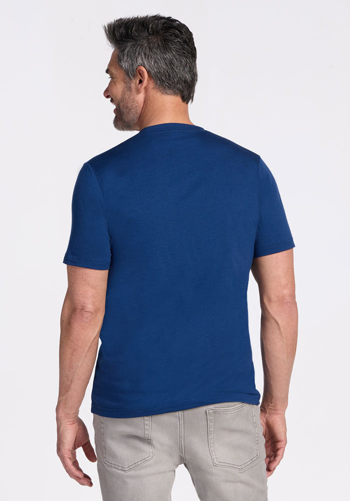 Man with gray hair wears a Woolx Endurance Tee in Estate Blue and light gray jeans, standing with his back to camera.