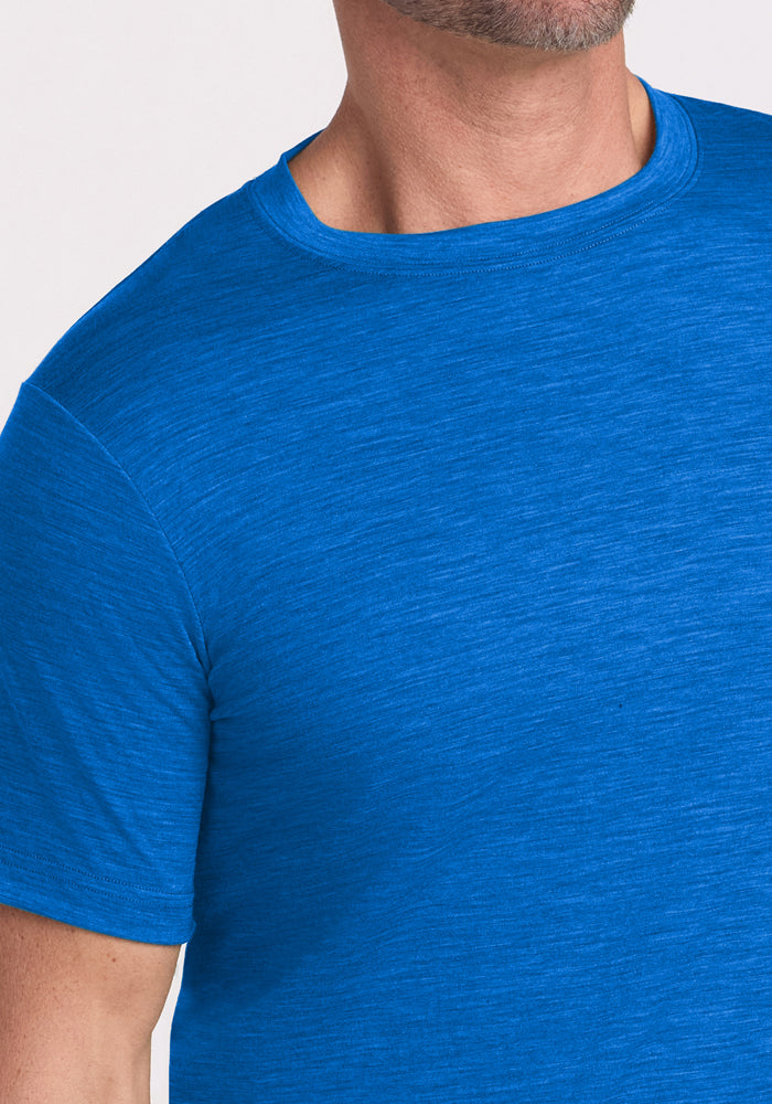 Man wearing Woolx Endurance Tee in Glacial Blue, shown shoulders to mid-arm with neck and chin visible.