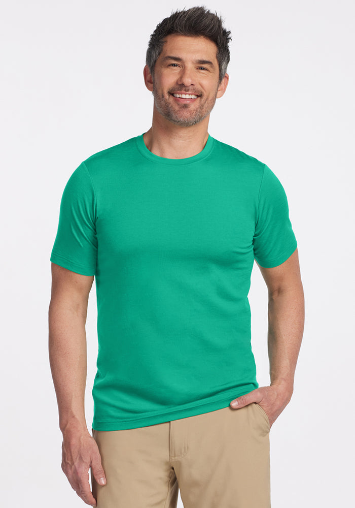 Man smiling in a Woolx Endurance Tee - Jungle and beige pants, standing against a plain white background. | Matthew is 6’, wearing a size L
