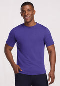 Smiling man in a Woolx Endurance Tee - Berry Indigo and dark pants, standing against a light background. | Trell is 6’2”, wearing a size M