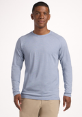 A man wearing the Woolx Essential Tee in Blue Sand Mini Stripe and beige pants stands smiling in front of a plain white background. | Trell is 6’2”, wearing a size M
