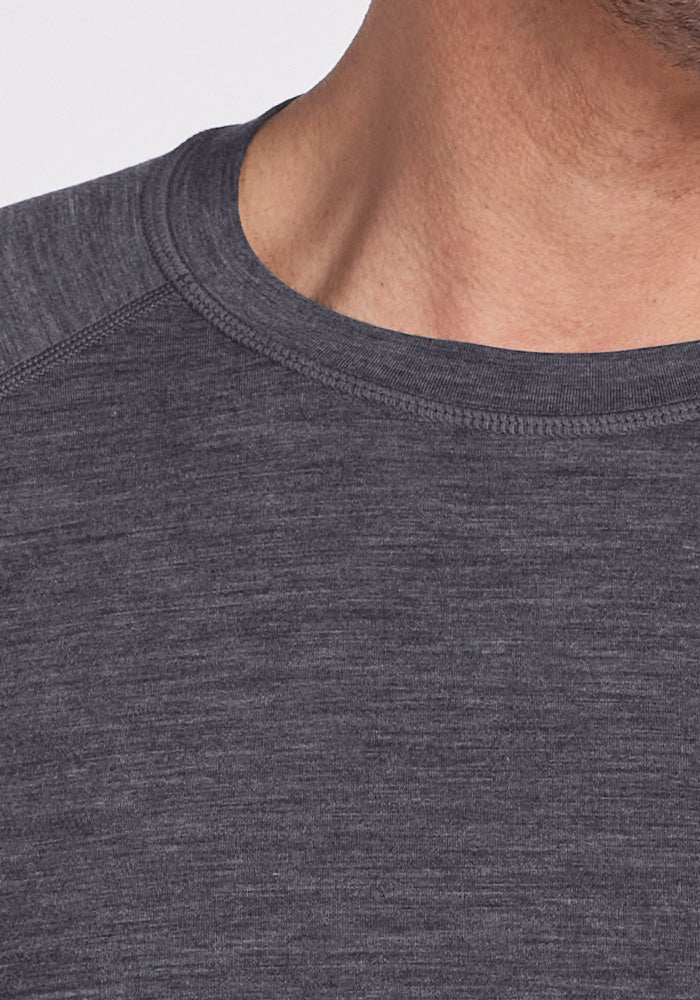 Close-up of a person wearing the Woolx Essential Tee in Cinder Melange, showing neck, shoulder, and collar.