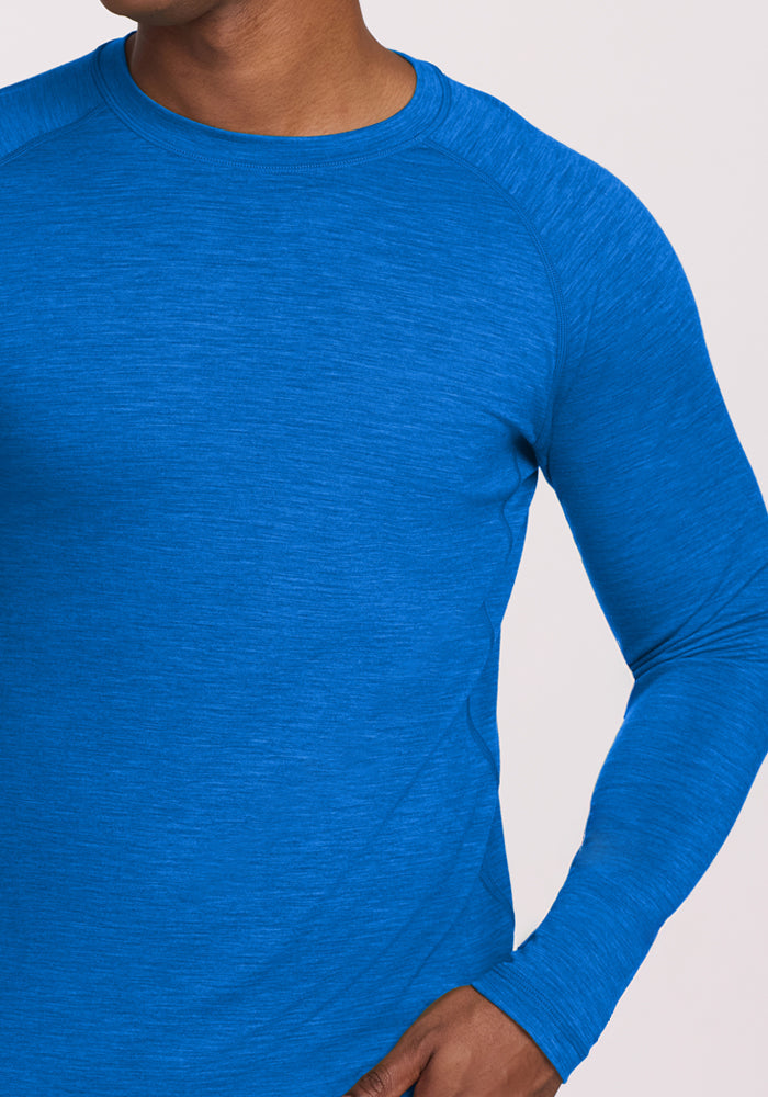 A person wears the Woolx Essential Tee in Glacial Blue, with one hand resting on their hip.