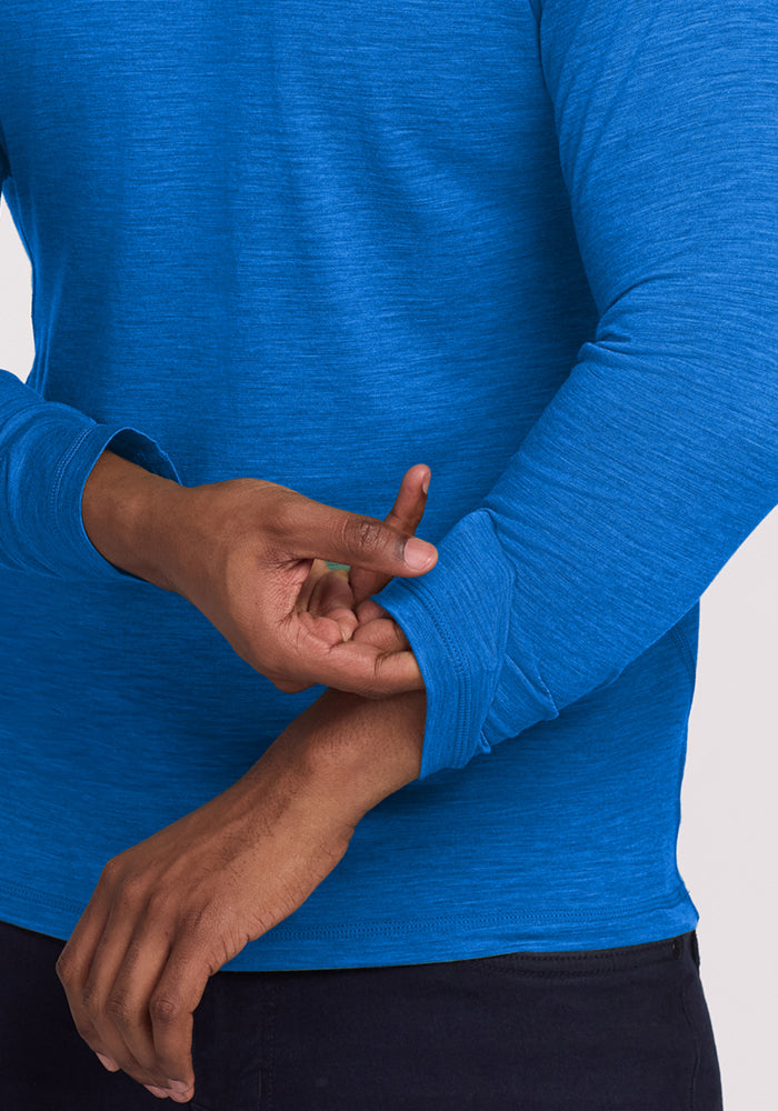 Person in a Woolx Essential Tee • Final Sale - Glacial Blue pulls up the sleeve with one hand.