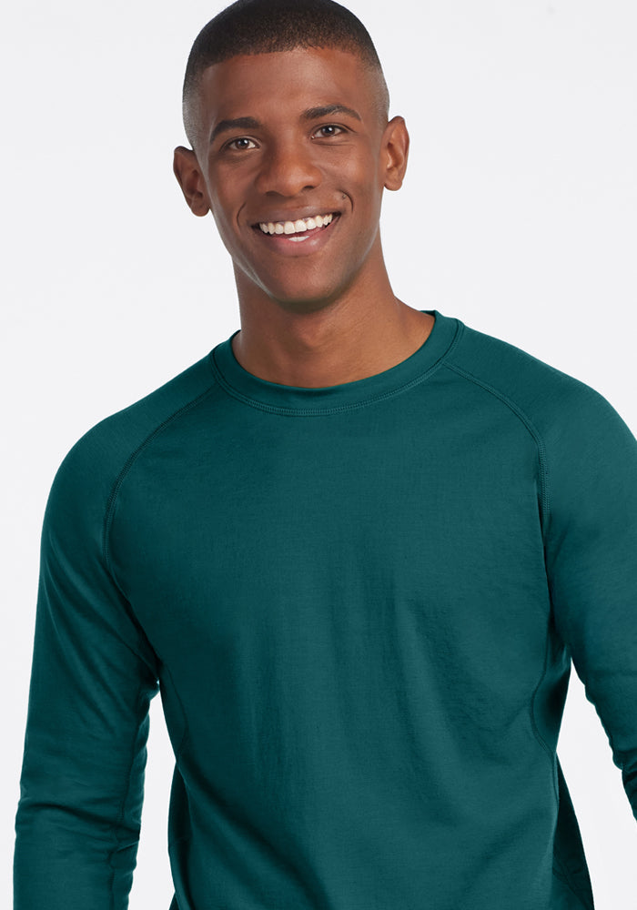 Smiling person in Woolx Essential Tee (Riverbank Green), final sale, against plain white background.