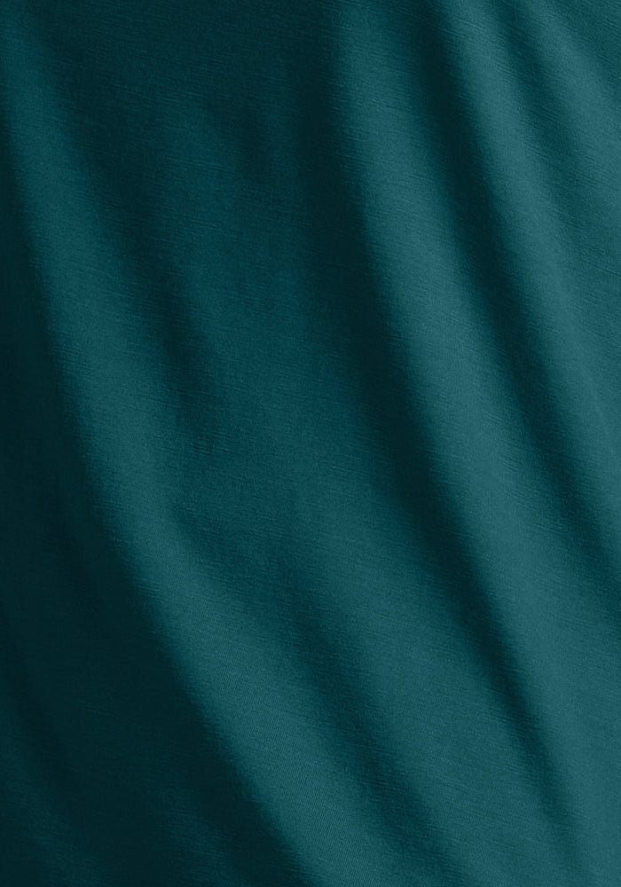 Woolx Essential Tee in Riverbank Green—Merino wool with soft diagonal folds, gentle shadows, and a smooth texture.