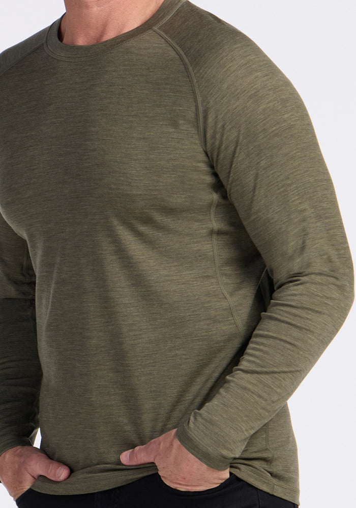Man wearing a fitted Woolx Essential Tee in Sage Olive Melange; lightweight and temperature regulating.