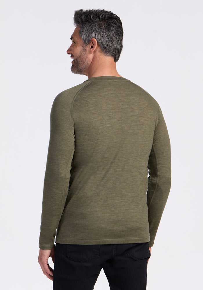 Man with short gray hair wears a Woolx Essential Tee in Sage Olive Melange, facing away from the camera.