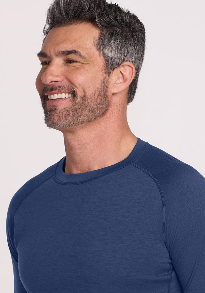 Smiling man with gray hair wears Woolx Essential Tee • Final Sale - Starry Night, facing left.