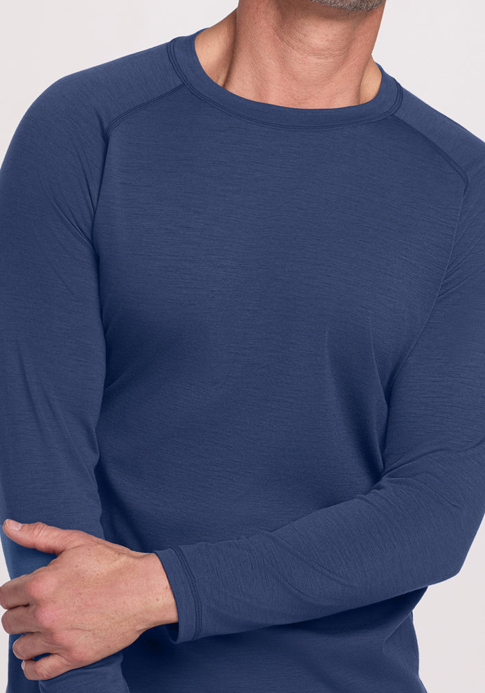 A man in a Woolx Essential Tee • Final Sale - Starry Night stands with his right hand on his left forearm.