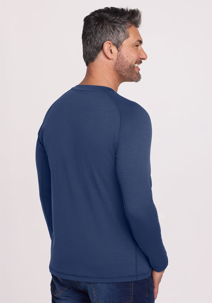 Man with short gray hair wears a Woolx Essential Tee in Starry Night, smiling, facing away, and wearing jeans.