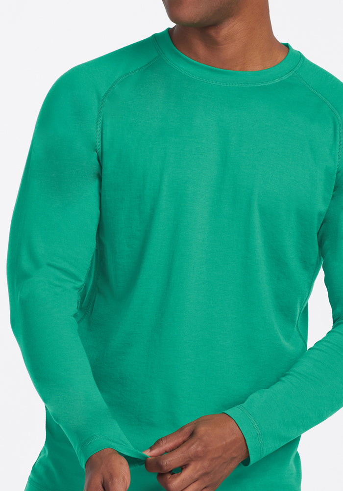 Person wearing a Woolx Essential Tee - Jungle, shown from shoulders to waist, against a plain background.