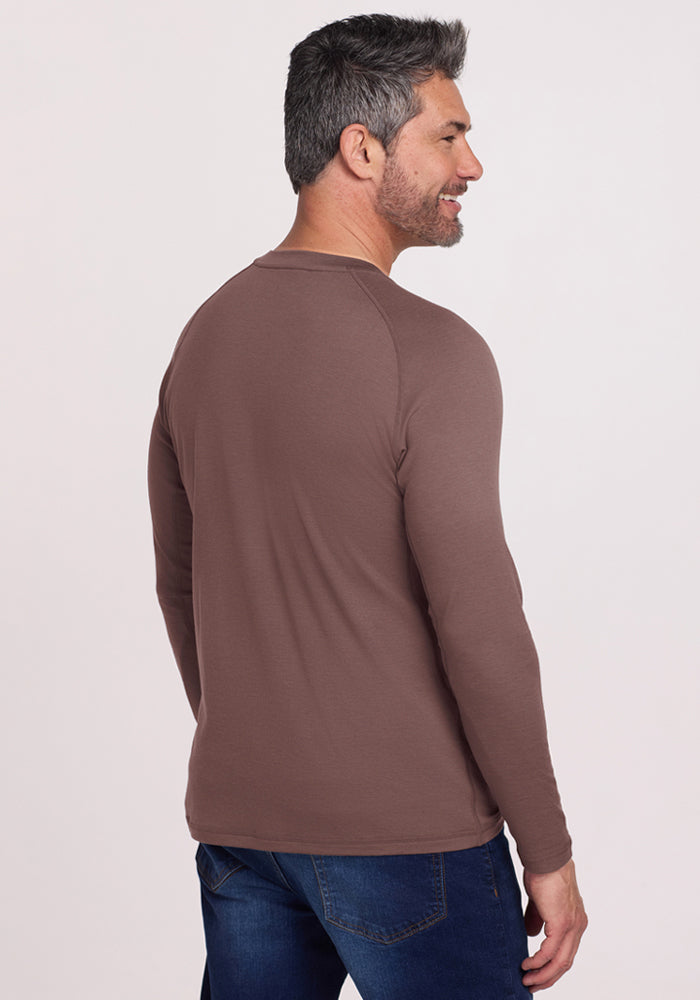 Man with short gray hair in a Woolx Essential Tee - Peppercorn stands smiling, enjoying temperature regulating comfort.