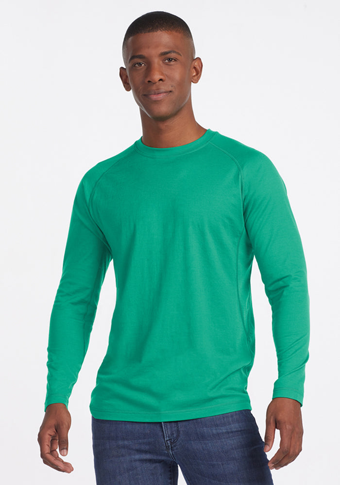 Man wearing the Woolx Essential Tee - Jungle and blue jeans, standing against a plain white background. | Trell is 6’2”, wearing a size M