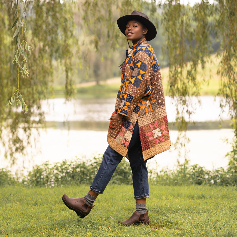 Woman in quilt wearing durable and versatile brown boots with dark jeans.