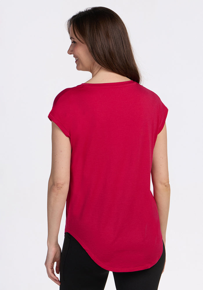 Woman with long brown hair in the Woolx Gabi Tunic Top - Poppy Spark, seen from the back, smiling.
