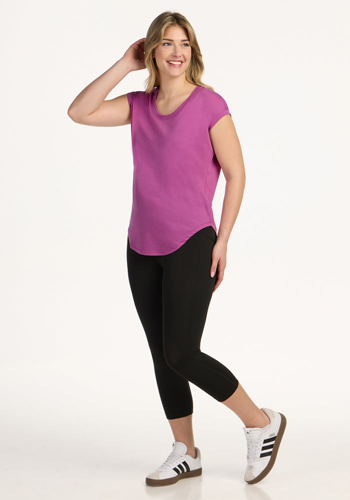 Woman wearing Woolx Gabi Tunic Top in Purple Wine, smiling and posing against a plain white background.