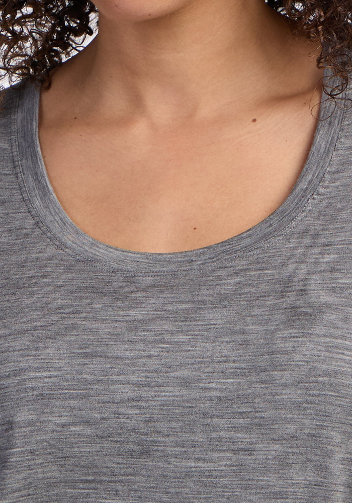 Close-up of a person wearing the Woolx Gabi Tunic Top in Graphite Heather. Only the lower face, neck, and part of their curly hair are shown.