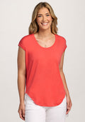 Smiling woman in the Woolx Gabi Tunic Top - Hibiscus and white pants against a plain light background. | Ariana is 5'11", wearing a size S