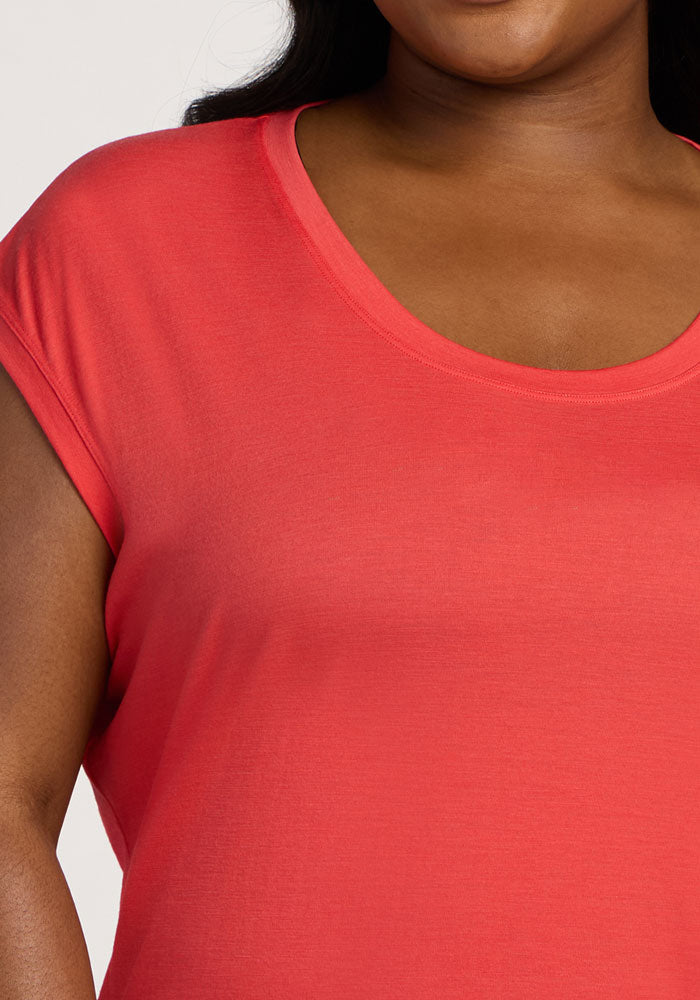 A person wearing the Woolx Gabi Tunic Top in Hibiscus, shown from shoulders to chest.
