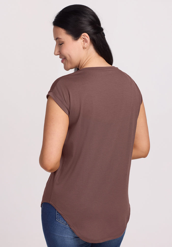 Woman with dark hair in a ponytail, smiling from behind, wears the Woolx Gabi Tunic Top - Peppercorn and blue jeans.