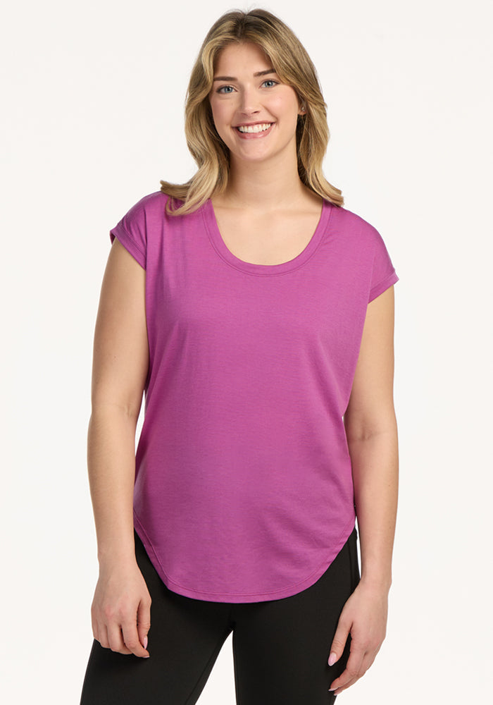 Woman smiling in the Woolx Gabi Tunic Top – Purple Wine, standing against a plain white background.