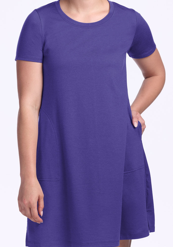 Person wearing the Woolx Georgie Dress in Berry Indigo, one hand in the pocket, against a light background.