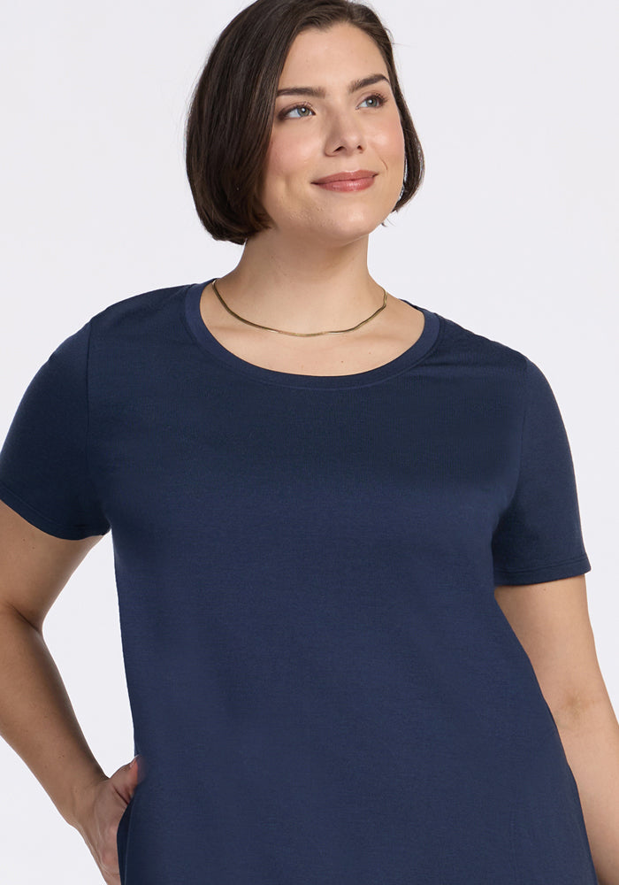 Woman with short brown hair in Woolx Georgie Dress • Final Sale - Deep Navy, wearing a gold necklace and smiling.