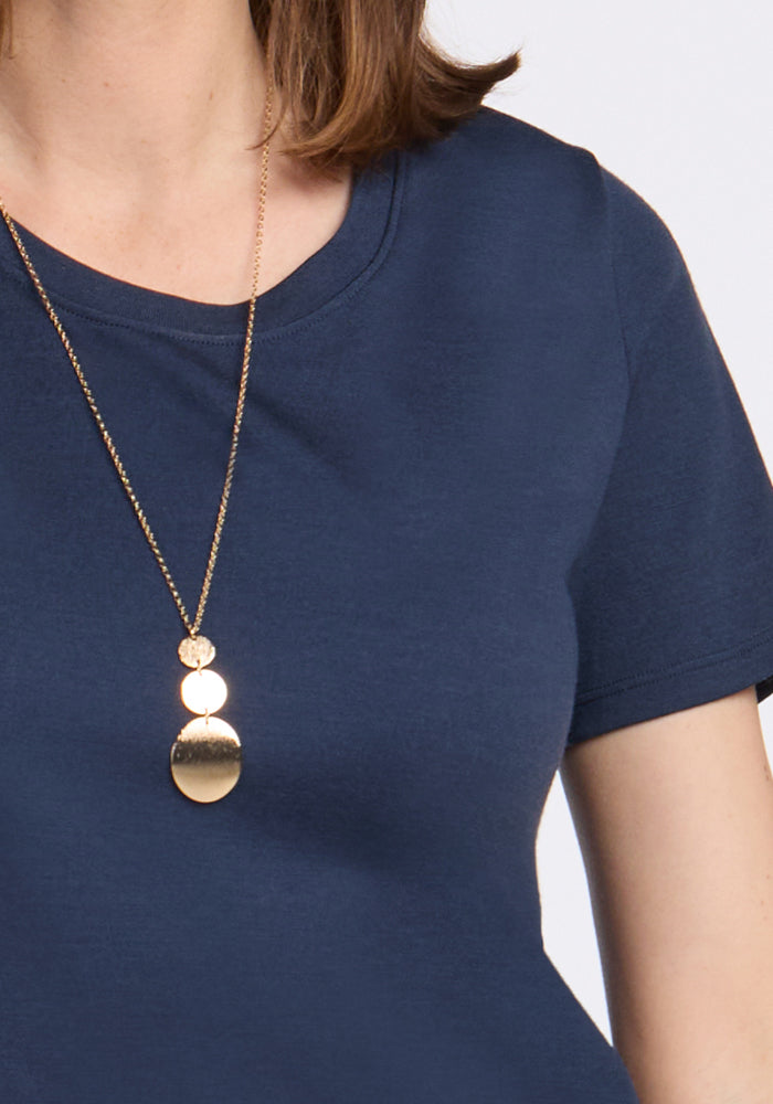 Woman wearing the Woolx Georgie Dress in Deep Navy and a gold pendant necklace with round and oval shapes.