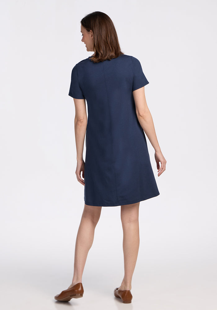 Woman in a Woolx Georgie Dress • Final Sale - Deep Navy, standing with her back to the camera.