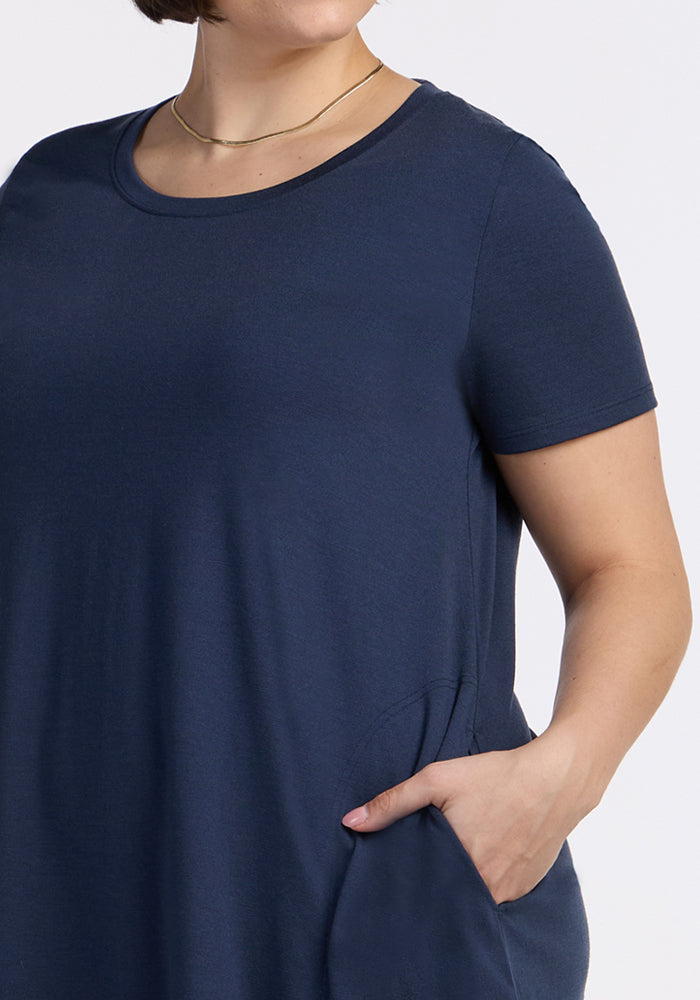 Woman wearing the Woolx Georgie Dress in Deep Navy, hand in pocket, styled with a thin gold necklace.