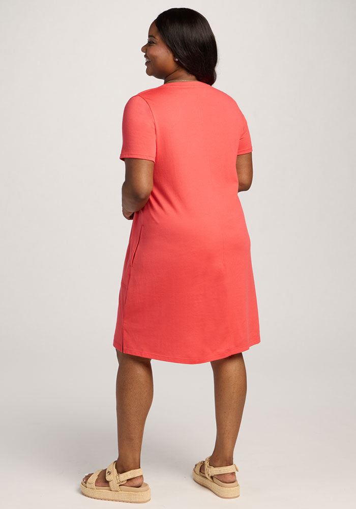 Woman smiling in the Woolx Georgie Dress - Hibiscus, shown from the back against a plain background.