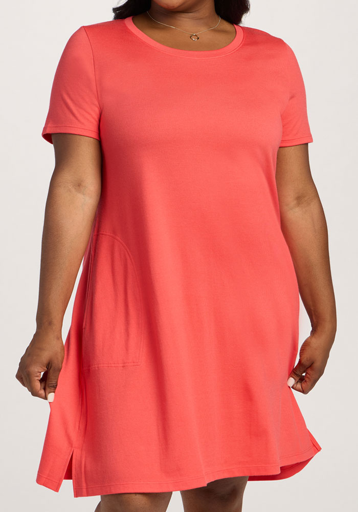 Woman wearing the Woolx Georgie Dress in Hibiscus, featuring short sleeves and a pocket, against a plain background.