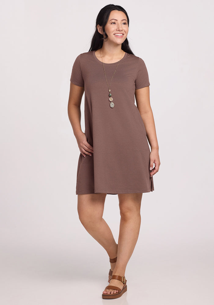 Woman wearing the Woolx Georgie Dress in Peppercorn, with a long necklace and sandals, smiling against a plain background. | Sarah is 5'8", wearing a size S