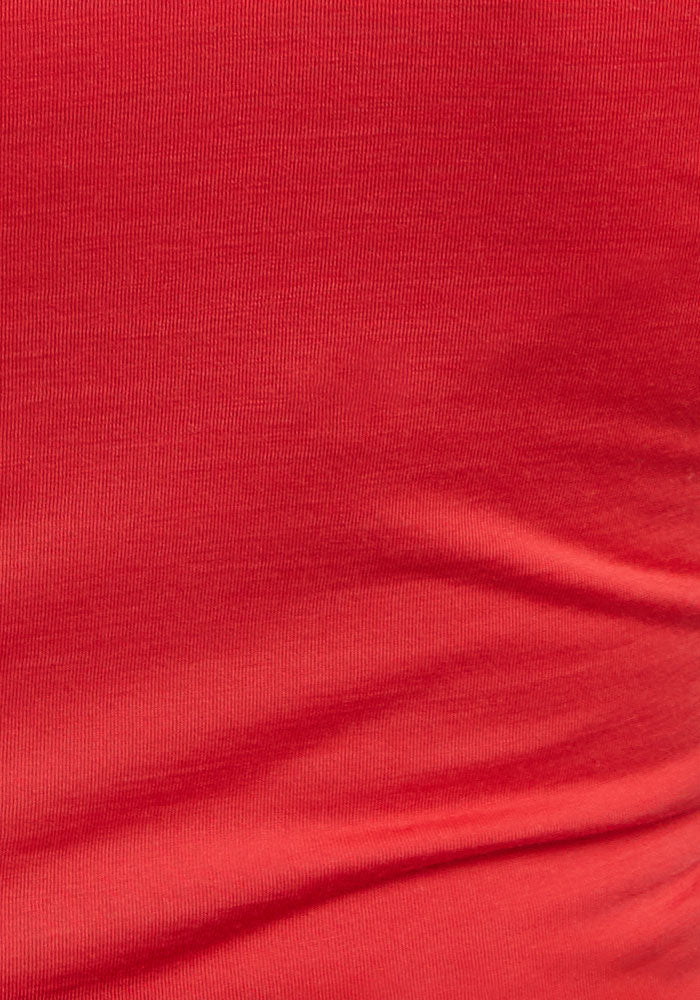 Close-up of Woolx Gracie Bodysuit - Hibiscus fabric showing fine ribbed red merino wool texture and soft folds.