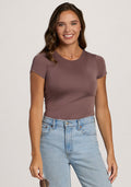Smiling woman with wavy brown hair wears the Woolx Gracie Bodysuit in Peppercorn and light blue jeans. | Madeleine is 5’10”, wearing a size XS